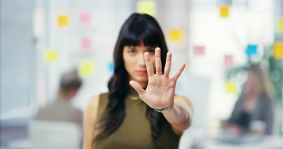 Woman holding out open hand to stop - Sexual Discrimination